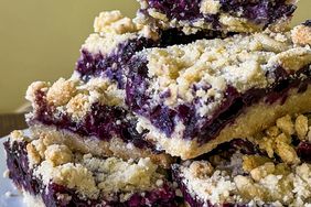 a low angle looking into a pile of stacked blueberry crumb bars