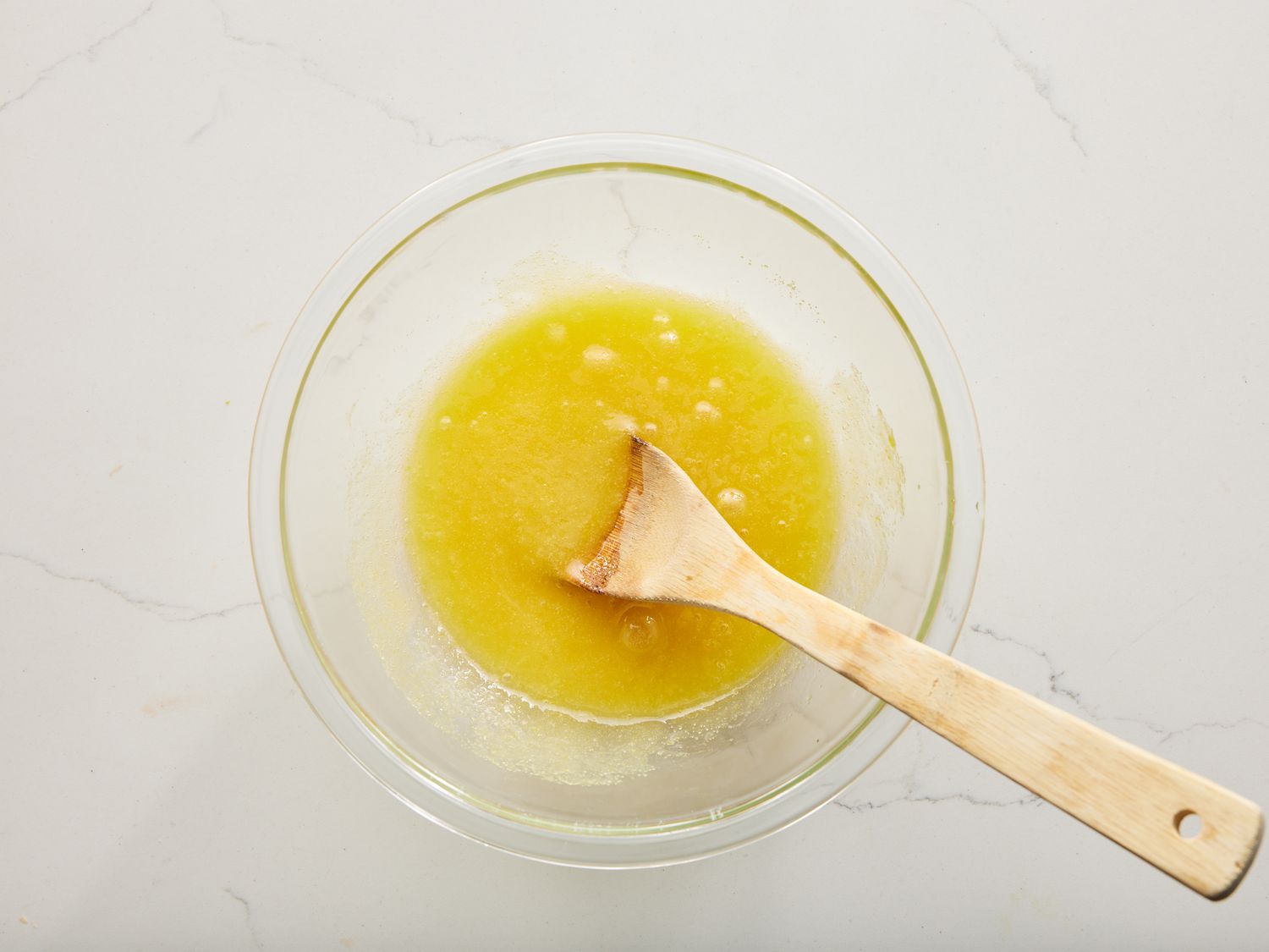 an overhead view of sugar, oil, and vanilla together in a medium bowl; beat in eggs until well combined