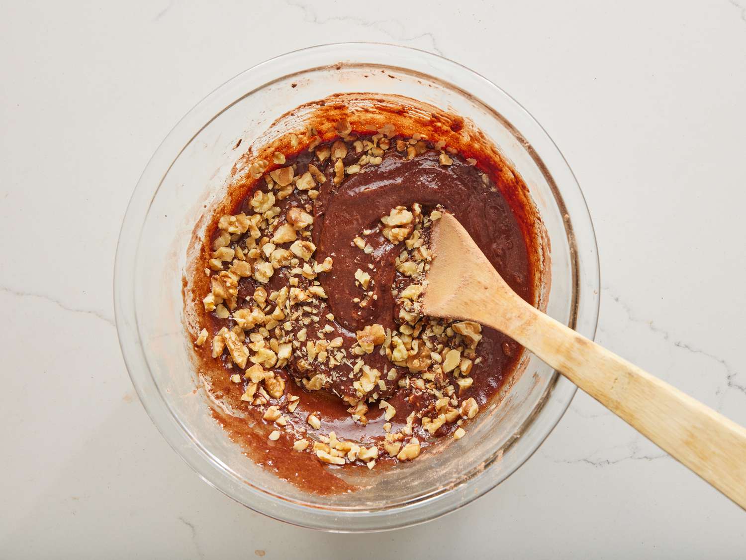 walnuts being stirred into brownie batter.