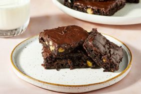 A plate with three frosted chocolate zucchini brownies