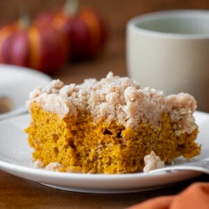 Piece of Pumpkin Spice Coffee Cake on a white plate with a bite taken out.