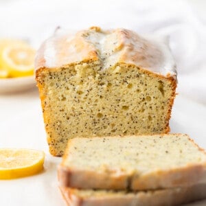 Loaf of Lemon Poppy Seed Bread with some slices cut and laying next to bread.