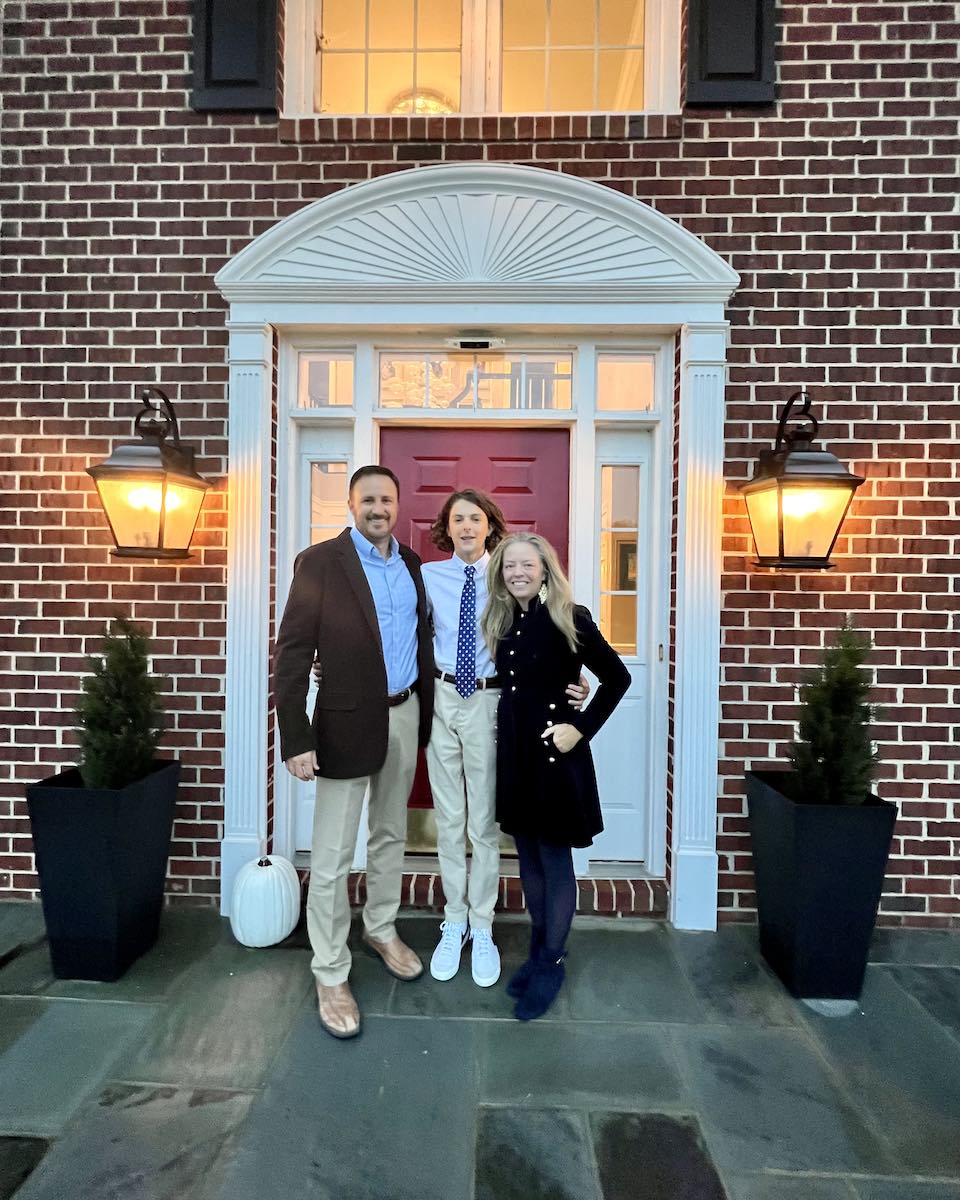 Heathered Nest front door paint color is SW Show Stopper - Heather, Dave, and son in front of brick front home with slate porch