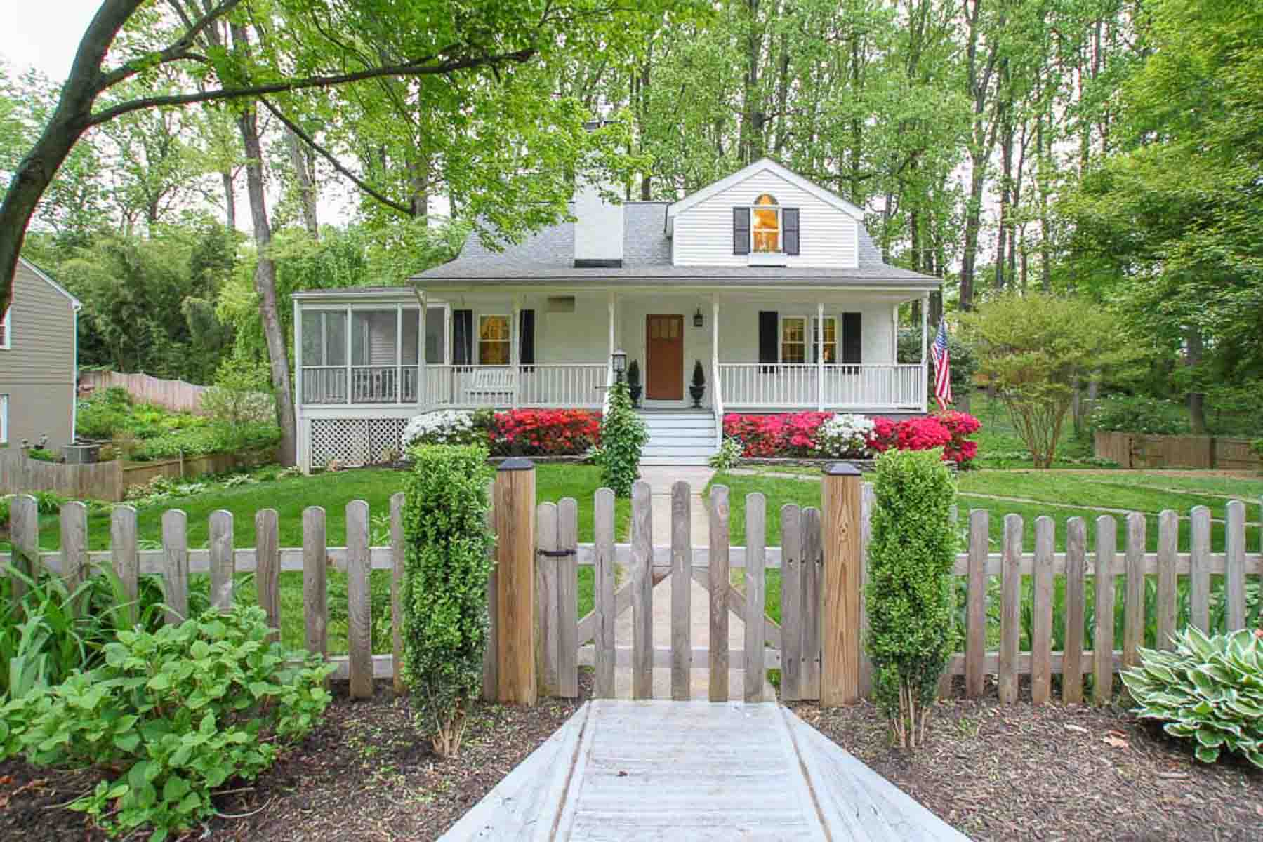 cape cod home with picket fence and front porch painted Benjamin Moore White Dove with black shutters